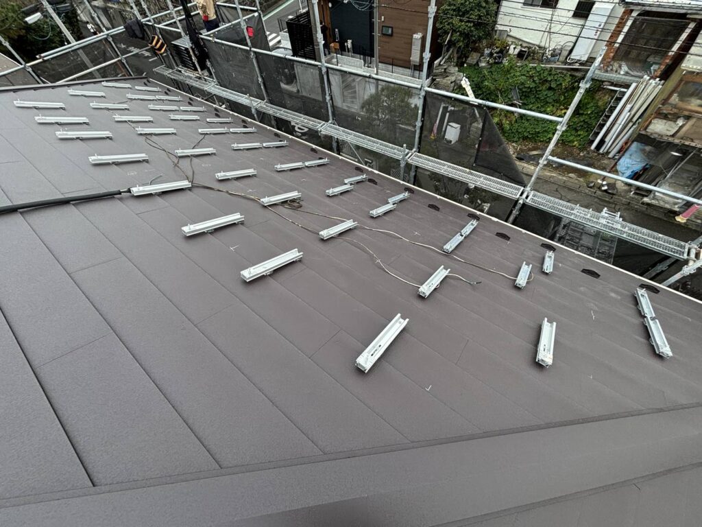 カバー工法で葺いた横葺き金属屋根に取り付けた、穴を開けない掴み金具